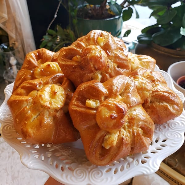 Golden brown pastries with sweet filling on a white decorative plate at Pistachio Cafe.